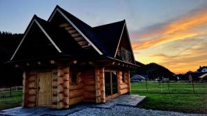 a small log cabin with a black roof at Domek W Sercu Gór in Ochotnica Górna