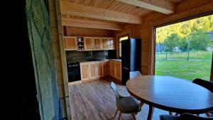 a small kitchen with a table and a refrigerator at Domek W Sercu Gór in Ochotnica Górna +13 photos