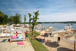 a group of people on a beach with umbrellas at Dubravka 1 in Funtana