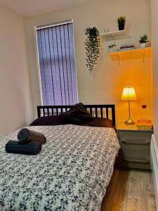 a bedroom with a bed and a desk and a window at Britlodge Ruskin Ave Home in Manchester