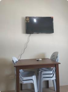 LagunaにあるRics Remarkable and Radiant Home in Dumaguete City - Marina Spatial B842のテーブル(椅子2脚付)、壁掛けテレビ