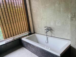 eine Badewanne mit einem Wasserhahn im Bad in der Unterkunft Oasis Residency and Resorts in Solapur + 63 Fotos