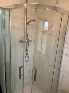 a shower in a bathroom with marble walls at Elstree Inn in Borehamwood +34 photos