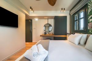 a bedroom with a large bed with towels on it at Nest by the Sea, Nilie Hospitality MGMT in Kala Nera +98 photos