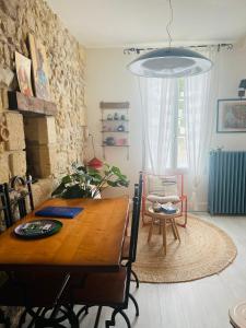una sala da pranzo con tavolo in legno e sedia di Le nid des Petits à 15 min de Bordeaux a Sainte-Eulalie
