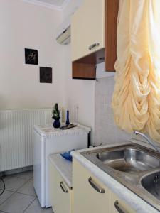 a kitchen with a sink and a refrigerator at Studio with cute garden space in Nydri