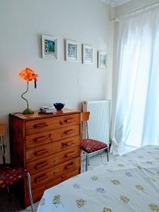 a bedroom with a dresser and a bed and two chairs at Studio with cute garden space in Nydri