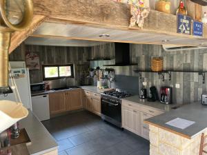 a kitchen with wooden cabinets and a stove top oven at EI Domaine du Bouygues chambres d'hôtes in Le Juge