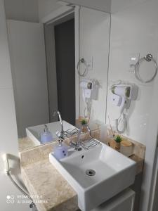 a bathroom with a white sink and a mirror at Hospedagem Altas da Quitéria Suíte 02 in Catas Altas