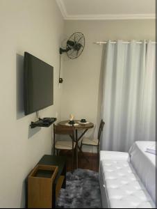 a living room with a television and a table with a couch at Hospedagem Altas da Quitéria Suíte 02 in Catas Altas