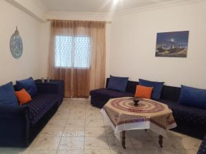 ein Wohnzimmer mit zwei Sofas und einem Tisch in der Unterkunft Appart à Martil in Martil + 1 Foto