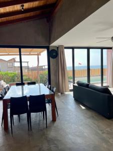 a dining room with a table and a couch at La Morada - Casa de playa frente al mar en Estreno in Canoas De Punta Sal