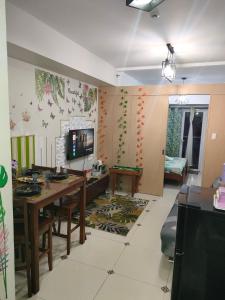 ein Wohnzimmer mit Tisch und Fernseher in der Unterkunft Smdc Wind Residences Tagaytay with Balcony 19th floor in Tagaytay