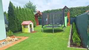 une aire de jeux avec une balançoire et une niche pour chien dans l'établissement Green cottage Besenova, à Bešeňová