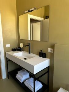 Un baño con un lavabo blanco y un espejo. en Casa di Luka, en Misano Adriatico 12 fotos más