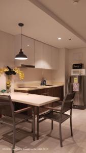 une cuisine avec une table, des chaises et un réfrigérateur dans l'établissement Seaview Condo with in Tambuli Resort and Spa, à Lapu Lapu City