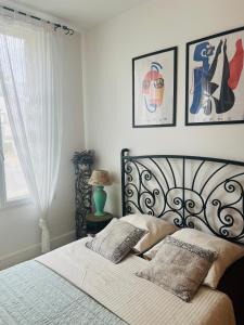 una camera da letto con un letto con due cuscini sopra di Le nid des Petits à 15 min de Bordeaux a Sainte-Eulalie