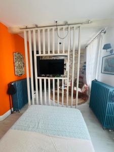 a bedroom with a crib in a room with orange walls at Le nid des Petits à 15 min de Bordeaux in Sainte-Eulalie
