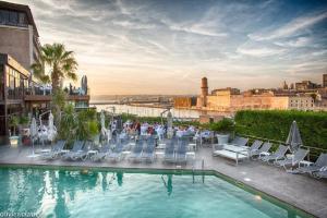 a group of people sitting in chairs next to a pool at Novotel Marseille Vieux Port in Marseille