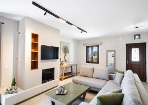 a living room with a couch and a tv at G&S House in Tsoukalades