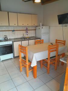 y cocina con mesa, sillas y fogones. en Departamento Elida, en San Rafael 25 fotos más