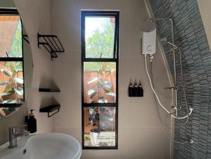 a bathroom with a sink and a shower with a window at Madria Loft Cabin in Baras