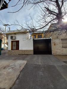una casa blanca con una puerta de garaje en una entrada en Departamento Elida, en San Rafael