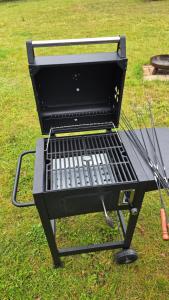 a grill sitting on the grass in a yard at Dom z Widokiem w Rajgrodzie in Rajgród +26 photos
