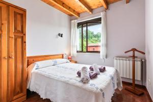 a bedroom with a bed with two stuffed animals on it at Romano I megustarural in Porrúa