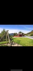 a picture of a fence with a house in the background at Hytte nært lutsivannet in Sandnes