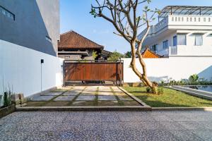 a gate in a building with a tree next to it at Villa Wibiseka Batuan in Sukawati