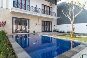 a swimming pool in front of a house at Villa Wibiseka Batuan in Sukawati