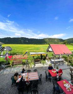 a group of people sitting at tables on a patio at imani homestay taman ira kangar perlis in Kangar +10 photos