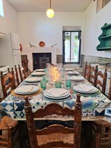 a dining room table with plates and glasses on it at Alquería de Tajarja in Tajarja