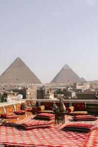 a pile of pillows on a table in front of pyramids at Cozy vintage duplex Khan -khan luxe residence pyramids view in Cairo
