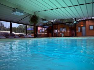 a large swimming pool with blue water at DUNjA Apartman in Vrnjačka Banja