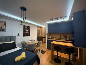 a bedroom with a bed and a kitchen with a table at DUNjA Apartman in Vrnjačka Banja