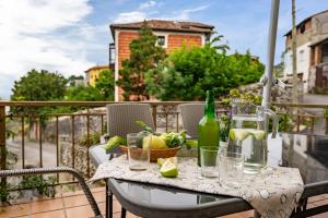 a table with glasses and a bottle on a balcony at Romano I megustarural in Porrúa