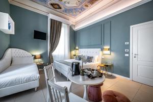 a bedroom with a bed and a table and a couch at Boutique Hotel La Casa di Morfeo in Florence +50 photos