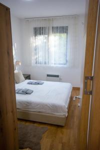a bedroom with a white bed and a window at Panorama Tornik Zlatibor P4 apartman in Zlatibor +50 photos