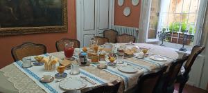a dining room table with food and plates on it at Lacetoliera Residenza d'epoca in Bosco Marengo