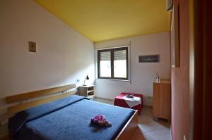 sypialnia z niebieskim łóżkiem i oknem w obiekcie Casa Vacanza Tortolì Plus VIII e IX w mieście Tortolì