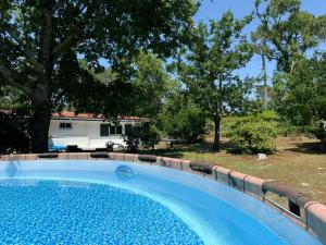 a swimming pool in a yard with a trailer at La Maison de la forêt et son jaccuzy in Biscarrosse