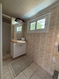 a bathroom with a sink and a window at La Maison de la forêt in Biscarrosse