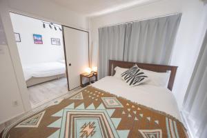 ein Schlafzimmer mit einem Bett und einem großen Fenster in der Unterkunft shan-Nishiochiai 2F in Tokio