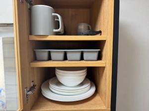 a cupboard with plates and a jug and a bowl at XLH2,7 Min by Train to Harry Potter Studio Tour, Quick Access to Shinjuku, Double Bed and Sofa Bed, Private Kitchen and Living Room, Sleeps 4 in Tokyo