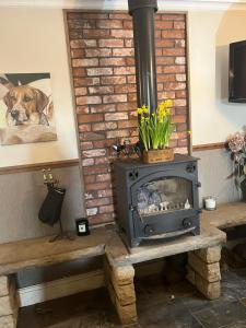 a wood stove sitting on a table in a room at Cottage Lea's Country Hotel & Restaurant in Pickering