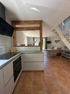 Una cocina con gabinetes blancos y una sala de estar. en Born 1A, en Born