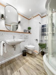 a bathroom with a sink and a toilet and a shower at Design-Apartment mit Meerblick in Travemünde +22 photos