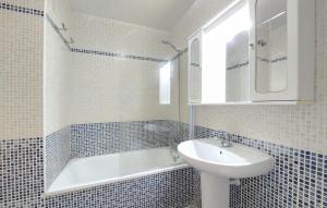 a white bathroom with a sink and a bath tub at Encantadora y acogedora casa in San Juan de Moró